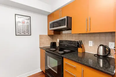 a kitchen with a stove and a microwave at Luxe 3BR 2 Bath Condo Steps from Square one Mall in Mississauga