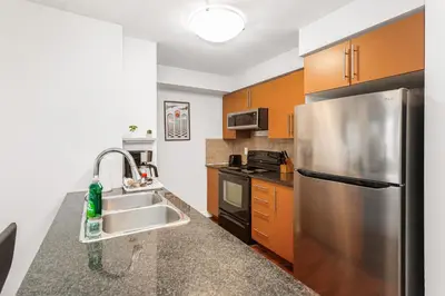 a kitchen with a stainless steel refrigerator and a sink at Luxe 3BR 2 Bath Condo Steps from Square one Mall in Mississauga