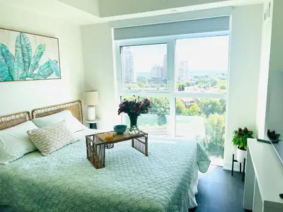 a bedroom with a bed and a table with flowers on it at Lakeview in Toronto