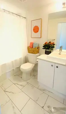 a white bathroom with a toilet and a sink at Lakeview in Toronto