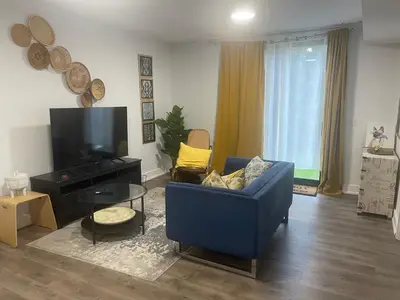 a living room with a blue couch and a tv at Self contained lower level 1 Bedroom apartment in Oshawa