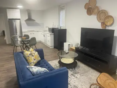 a living room with a blue couch and a tv at Self contained lower level 1 Bedroom apartment in Oshawa