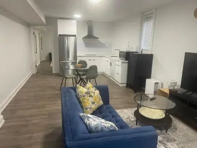 a living room with a blue couch and a kitchen at Self contained lower level 1 Bedroom apartment in Oshawa