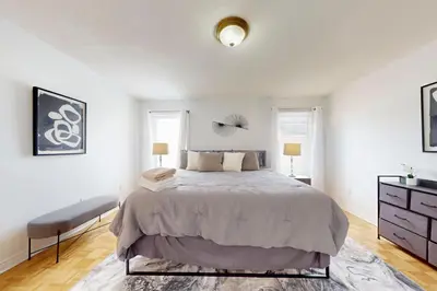 a bedroom with a large bed and two windows at Charming 4-bed Home Away From Home in Brampton, ON in Brampton