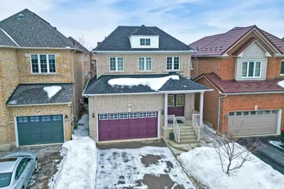 a house with purple garage doors in the snow at Charming 4-bed Home Away From Home in Brampton, ON in Brampton