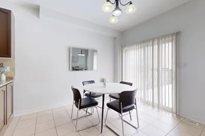 a kitchen and dining room with a table and chairs at Charming 4-bed Home Away From Home in Brampton, ON in Brampton