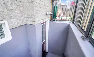 a balcony with a window and a brick wall at Stylish Modern 2-bedroom Basement Suite in Brampton