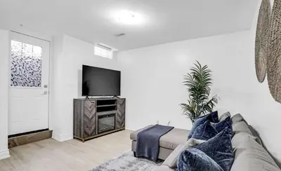 a living room with a couch and a flat screen tv at Stylish Modern 2-bedroom Basement Suite in Brampton