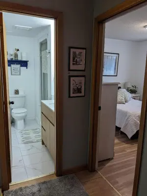a bathroom with a sink and a toilet and a bed at Cozy home away from home, close to hospital, college, and university with free parking in Peterborough