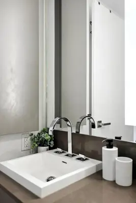 a bathroom sink with two faucets and a mirror at Modern Studio Retreat in Downtown Toronto in Toronto