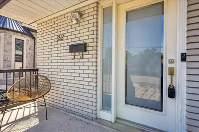a porch with a chair and a glass door at Bright 3-BDRM House, Family Home & Parking, YYZ Airport in Mississauga