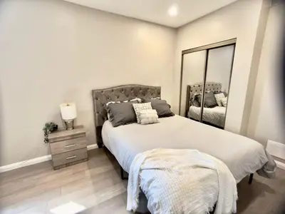 a bedroom with a large bed and a mirror at The Simple Escape, Walkout Basement on Ravine in Kitchener