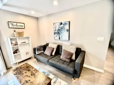 a living room with a couch and a table at The Simple Escape, Walkout Basement on Ravine in Kitchener