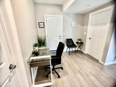 an office with a glass desk and a chair at The Simple Escape, Walkout Basement on Ravine in Kitchener