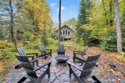 a group of chairs sitting around a fire pit at Muskoka Waterfront Cottage with Canoes and Fire Pit in Huntsville