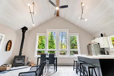 a kitchen with chairs and a stove in a room at Muskoka Waterfront Cottage with Canoes and Fire Pit in Huntsville
