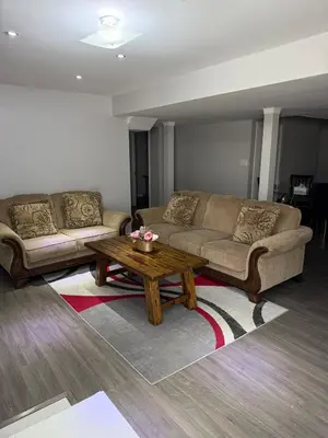 a living room with two couches and a coffee table at Beautiful&Spacious 2 Bedroom Basement Family Suite in Bradford