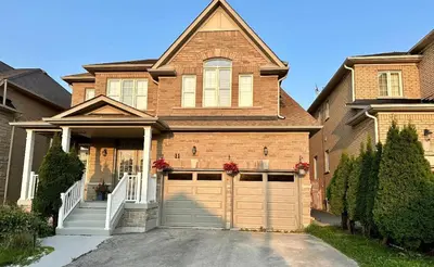a brown brick house with a garage at Beautiful&Spacious 2 Bedroom Basement Family Suite in Bradford