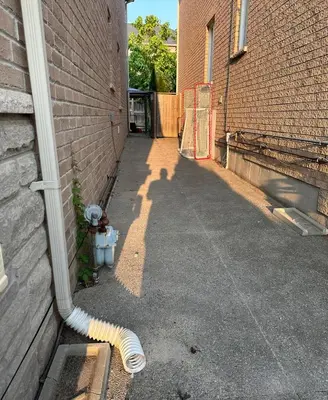 a hose is attached to the side of a building at Beautiful&Spacious 2 Bedroom Basement Family Suite in Bradford