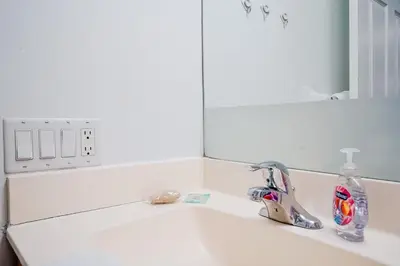 a white bathroom sink with a mirror above it at Elegant 2BR 2BA Condo Heart of Mississauga SQ1 in Mississauga