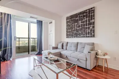 a living room with a couch and a glass table at Elegant 2BR 2BA Condo Heart of Mississauga SQ1 in Mississauga