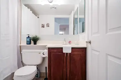 a bathroom with a toilet and a sink and a mirror at Elegant 2BR 2BA Condo Heart of Mississauga SQ1 in Mississauga
