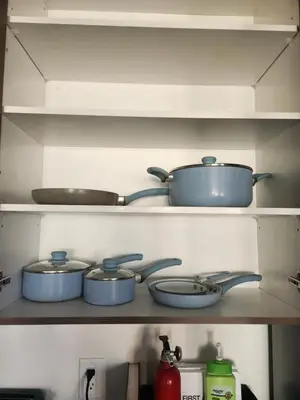 four pots and pans on a shelf in a kitchen at Cozy Home for 10 people in Kitchener