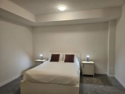 a bedroom with a large bed with two night stands at Cozy Home for 10 people in Kitchener
