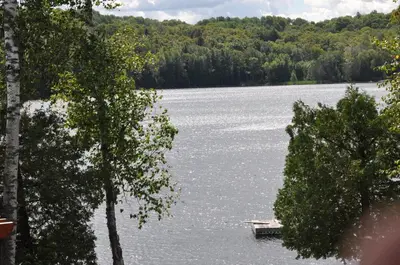 a lake with a dock in the middle of it at Serendipity 5 BR Waterfront 4 Seasons, Hot Tub, Firepit, Close to Ski HIll in Haliburton