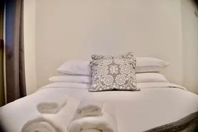 a white bed with a pillow and towels on it at Serendipity 5 BR Waterfront 4 Seasons, Hot Tub, Firepit, Close to Ski HIll in Haliburton