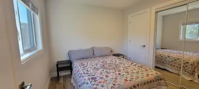 a small bedroom with a bed and a mirror at Bright Garden Suite 1 Bedroom and Den in Toronto