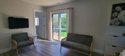 a living room with two chairs and a television at Bright Garden Suite 1 Bedroom and Den in Toronto