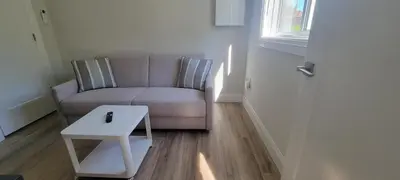 a living room with a couch and a table at Bright Garden Suite 1 Bedroom and Den in Toronto