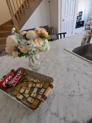 a table with a basket of snacks and a vase of flowers at Modern Stylish Cozy Home Balcony Wifi in Caledonia