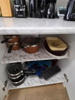 a kitchen shelf filled with pots and pans at Modern Stylish Cozy Home Balcony Wifi in Caledonia