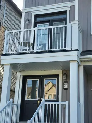 a house with a black door and a balcony at Modern Stylish Cozy Home Balcony Wifi in Caledonia