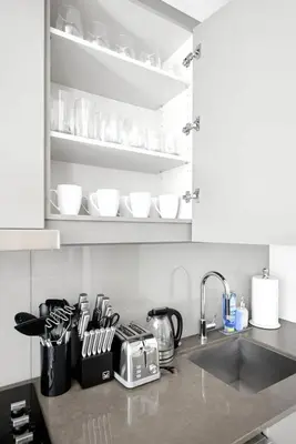 a kitchen counter with a sink and white cabinets at Trendy 1BR in TO Steps to Entertainment & Dining in Toronto