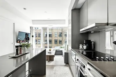 a kitchen with a counter and a living room at Trendy 1BR in TO Steps to Entertainment & Dining in Toronto