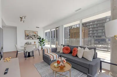 a living room with a couch and a table at Prime 2BR Condo with Massive Patio & Parking in Toronto