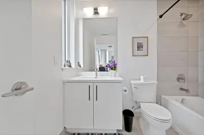 a white bathroom with a sink and a toilet at Hydropool Spa Hot Tub Bowling Alley Patio BBQ Games in Kitchener