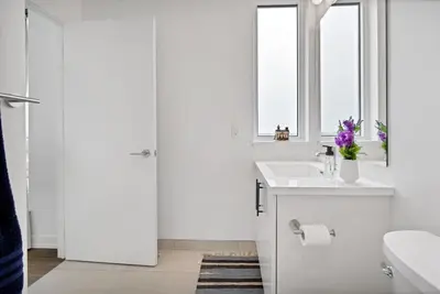 a white bathroom with a sink and a window at Hydropool Spa Hot Tub Bowling Alley Patio BBQ Games in Kitchener