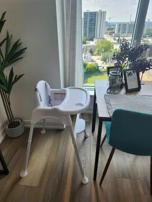 a white high chair and a table in a room at Hydropool Spa Hot Tub Bowling Alley Patio BBQ Games in Kitchener