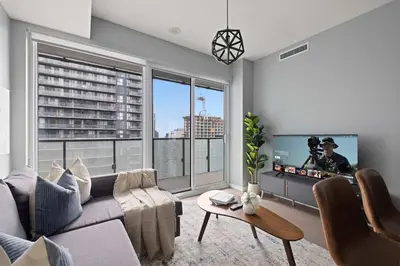a living room with a couch and a flat screen tv at Chic 1-Bedroom Downtown Toronto Getaway in Toronto