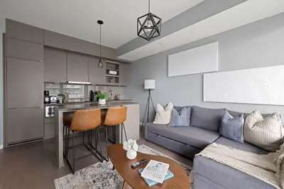 a living room with a couch and a kitchen at Chic 1-Bedroom Downtown Toronto Getaway in Toronto