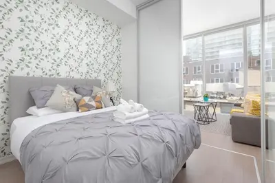 a bedroom with a large bed with a floral wallpaper at Chic 1BR King Suite TOs Entertainment District in Toronto