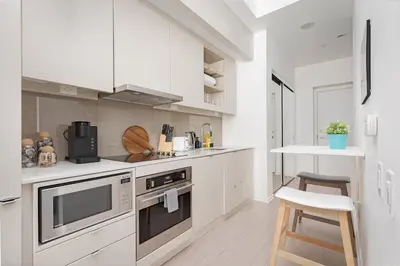 a kitchen with white cabinets and a stove top oven at Chic 1BR King Suite TOs Entertainment District in Toronto