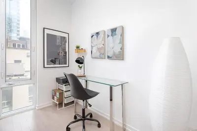 a office with a glass desk and a chair at Chic 1BR King Suite TOs Entertainment District in Toronto