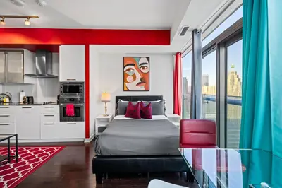 a bedroom with a bed and a kitchen withwindows at Fort York Studio a Cozy Retreat in Downtown in Toronto