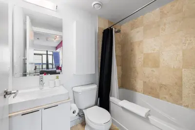 a bathroom with a toilet and a sink and a tub at Fort York Studio a Cozy Retreat in Downtown in Toronto