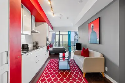 a living room with a couch and a red rug at Fort York Studio a Cozy Retreat in Downtown in Toronto